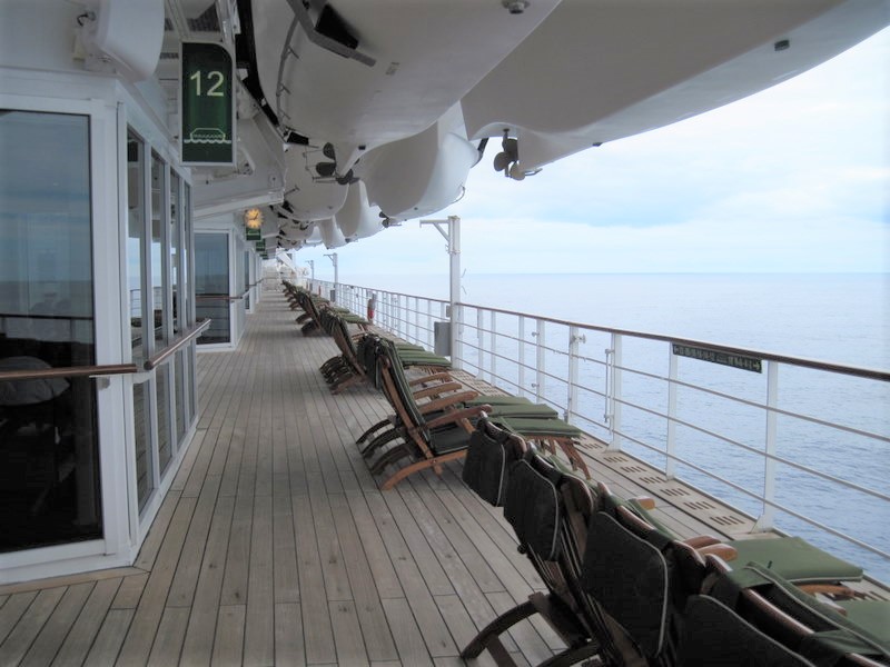 The wrap around prominade deck on Queen Mary 2 with traditional wood deck chairs